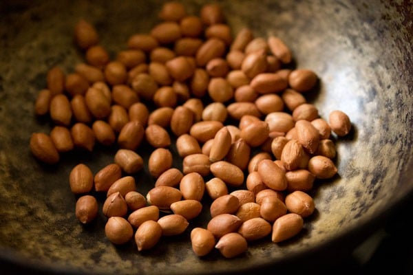 raw peanuts added to the hot pan for making sesame laddu. 