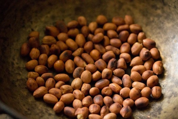 dry roasting peanuts in hot pan for making sesame laddu. 