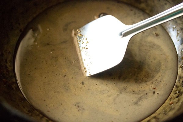 stirring jaggery into the water in the pan kept on low heat. 