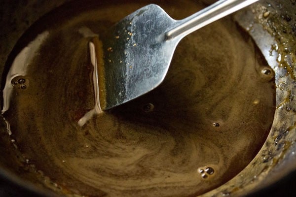 stirring jaggery into the water to make jaggery syrup. 