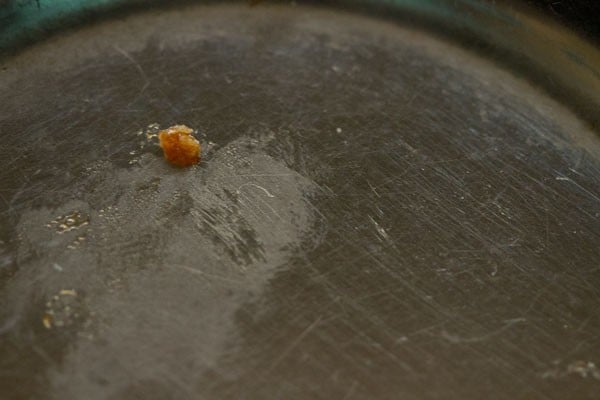 checking soft ball stage of jaggery syrup. 