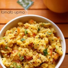 tomato upma served in a bowl with a side of tea