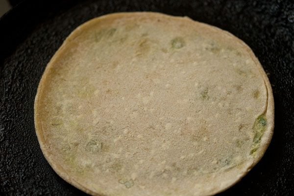 cooking peas paratha on tawa