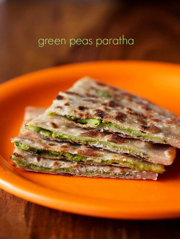 green peas paratha wedges served on a orange plate with text layover.