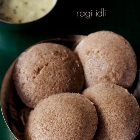 ragi idli servido en un tazón con un tazón de chutney de coco en la parte superior y escalas de texto.