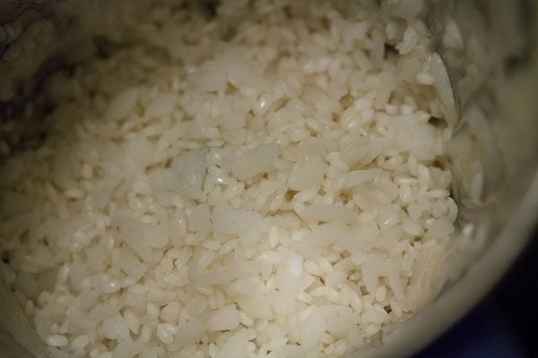 drained idli rice and poha mixture added to the grinder jar along with some water. 