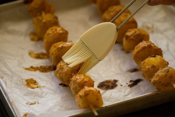 brushing aloo tikka midway while grilling. 