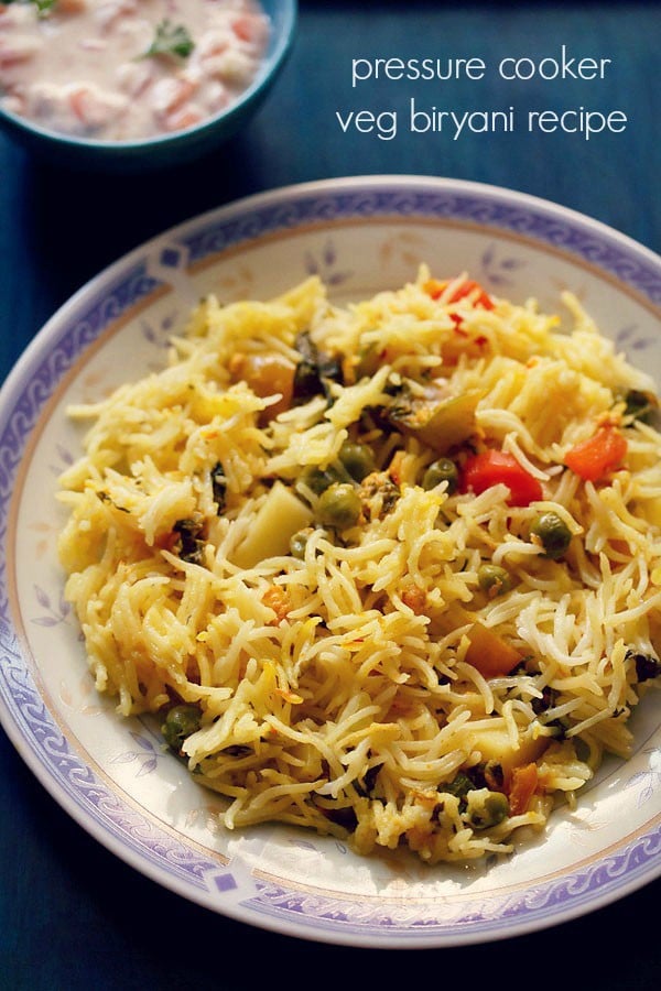 pressure cooker biryani on a white plate with a purple and golden design on the rim.