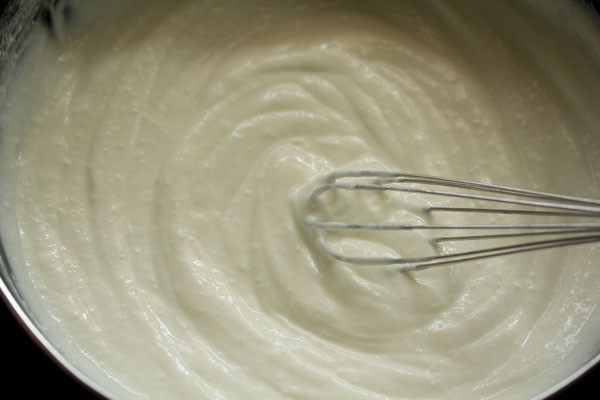 whisking curd till smooth in a bowl. 