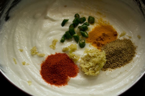 chopped green chilies, spice powders and ginger-garlic paste added to curd. 