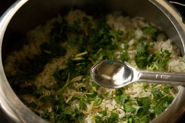 adding rose water on the rice. 