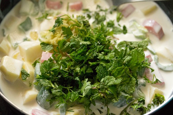 ginger-garlic paste, chopped coriander leaves and chopped mint leaves added to coconut milk. 