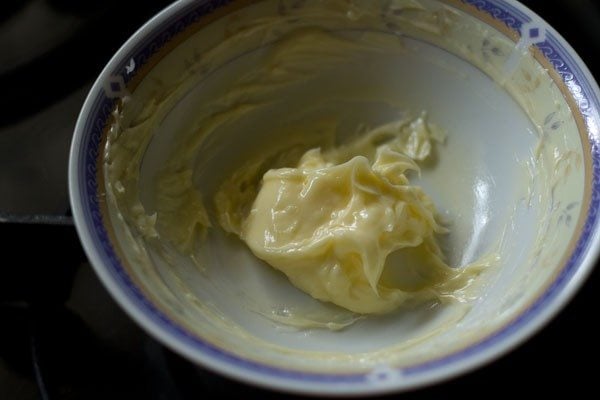 mezclando el ajo rallado con la mantequilla en el bol. 