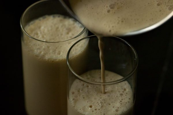 pouring cold coffee with ice cream into glasses.