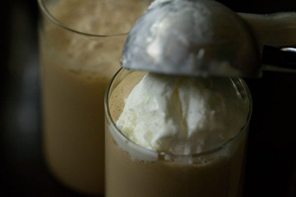 adding scoops of ice cream to glasses with cold coffee.