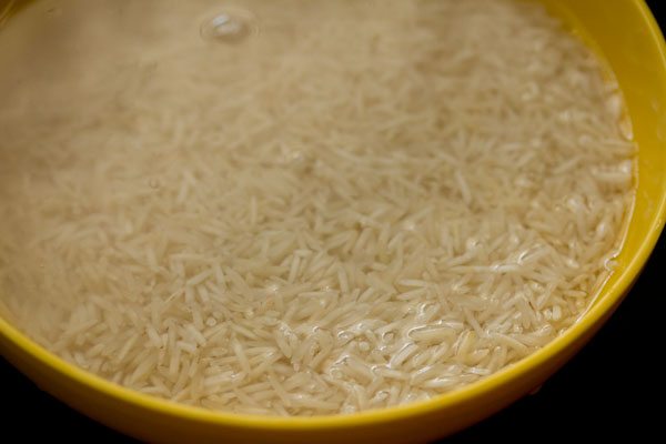 basmati rice soaking in water in yellow bowl