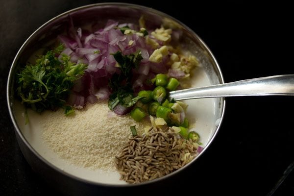 rava, onion, curry leaves, ginger, green chiles, cumin seeds, and cilantro added to the idli batter for making punugulu fritters.