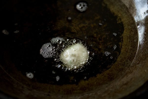 testing a small amount of punugulu batter in the frying oil.