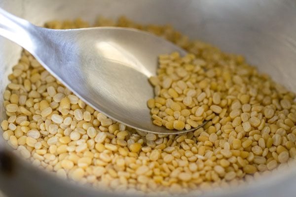 roasting mung lentils with a spoon