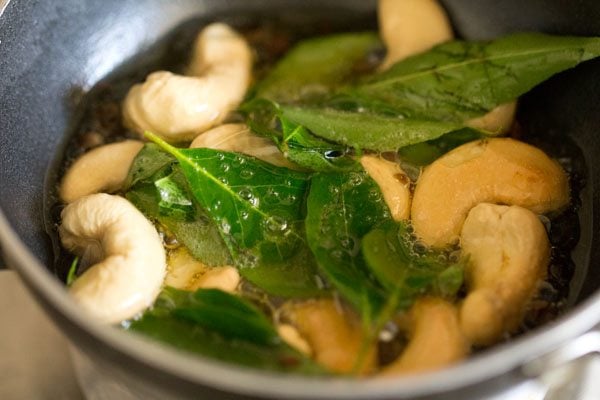 frying curry leaves, black pepper and cashews
