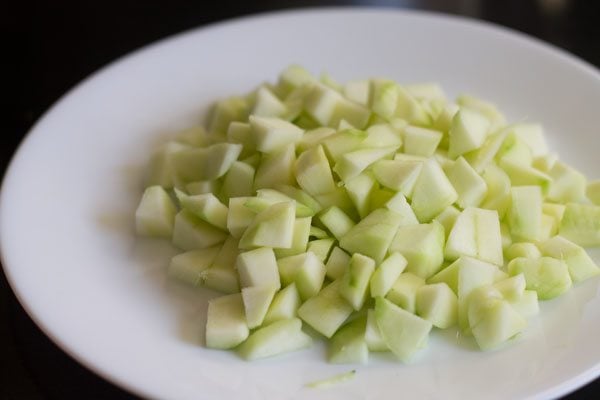 mangoes further chopped in small cubes and kept on a white plate.