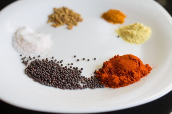spices kept on a plate for the kerala style instant mango pickle. 