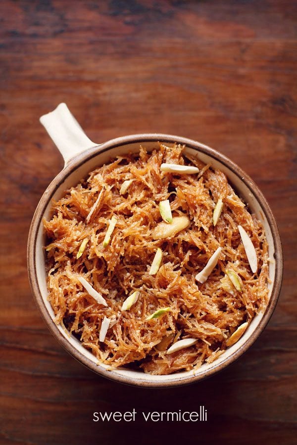 meethi seviyan garnished with almond slivers and served in a brown rimmed bowl with text layover.