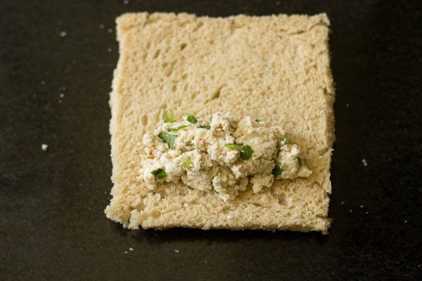 paneer stuffing placed on one side of the flattened bread slice. 