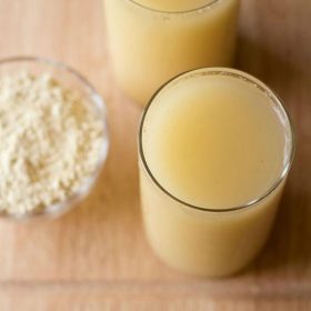 sattu drink served in 2 glasses with a bowl of sattu kept on the left side.