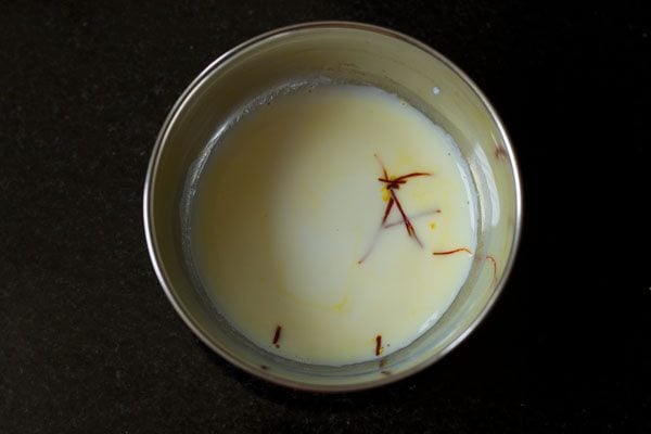 milk and saffron strands in a steel bowl 