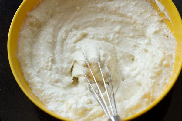 greek yogurt being whipped with wired whisk