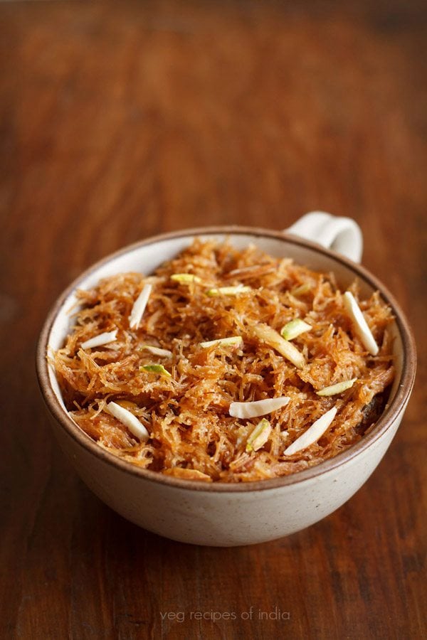 meethi seviyan garnished with almond slivers and served in a brown rimmed bowl with text layover. 