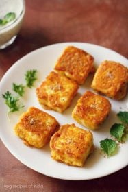 paneer amritsari garnished with coriander sprigs, mint leaves and served on a white colored plate with text layover.