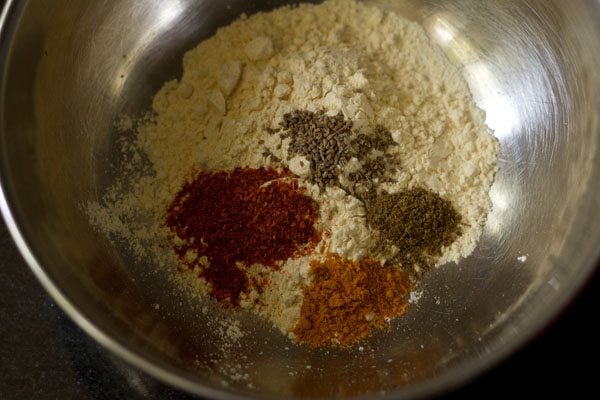 spice powders added to the gram flour in the bowl. 