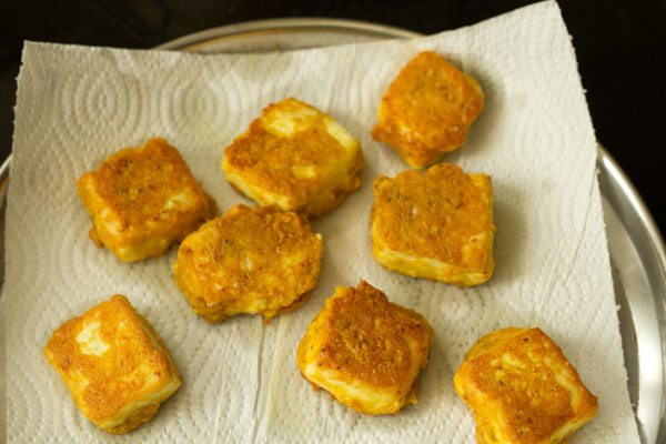 fried paneer cubes on kitchen paper towel. 