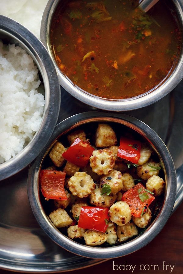 baby corn fry served in a bowl with sambar and rice.