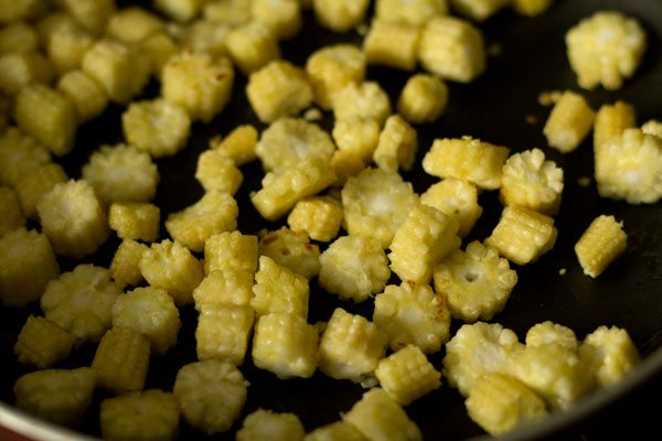 sautéing baby corn in pan.