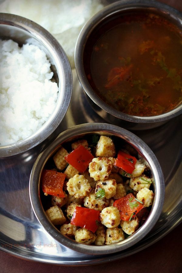 baby corn fry served in a bowl with sambar and rice. 