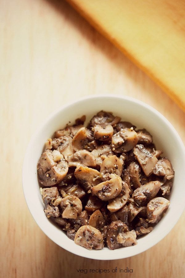 garlic butter mushroom served in a white bowl with text layovers. 