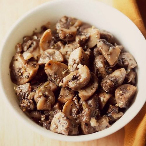 garlic mushrooms served in a white bowl.