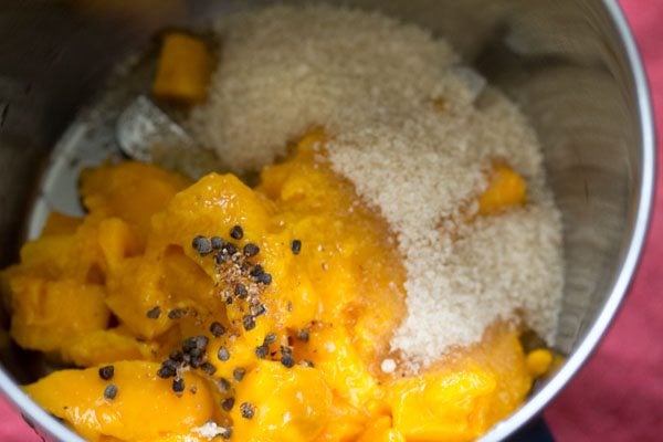 chopped mangoes, sugar, cardamom seeds and nutmeg powder in a blender. 