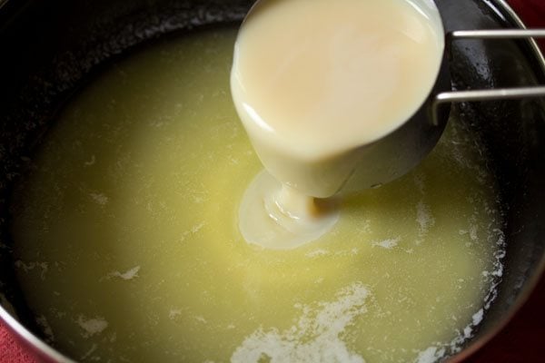 adding sweetened condensed milk to the melted butter in the pan. 