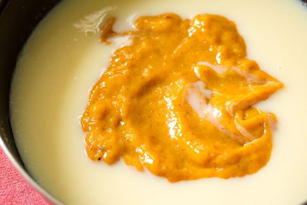 prepared mango puree added in the pan. 