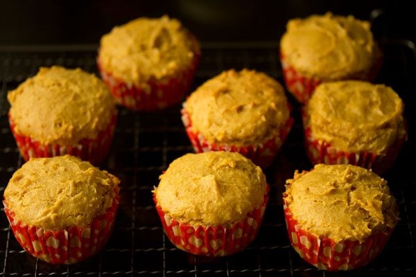 baked mango muffins placed on a wired tray. 