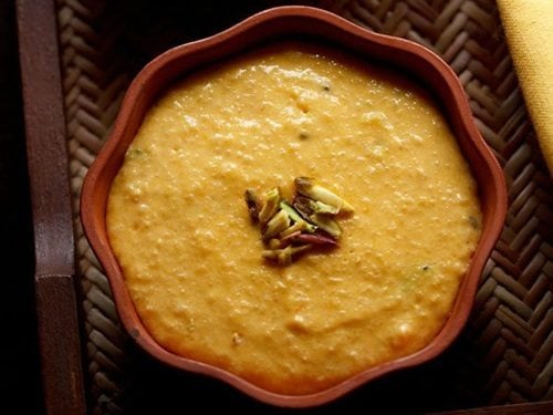 closeup shot of mango phirni in an earthen bowl.