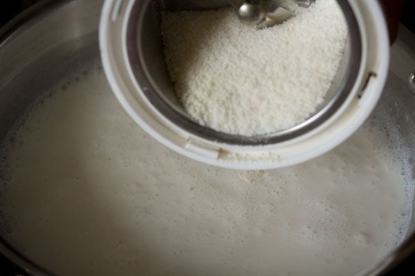 adding ground rice granules to the boiling milk. 