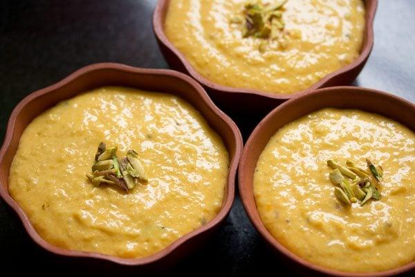 mango phirni garnished with sliced pistachios. 