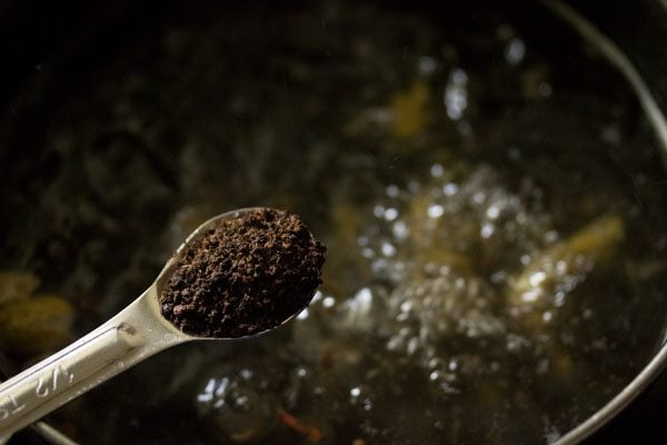 Assam tea being added with a teaspoon