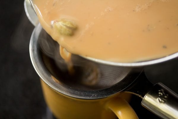 Masala tea being strained into a cup
