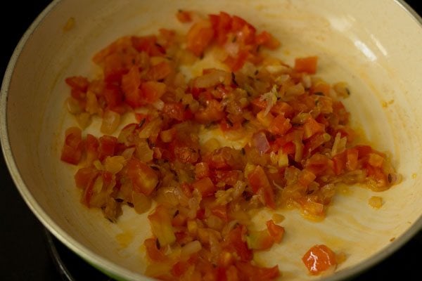 mixing tomatoes with masala